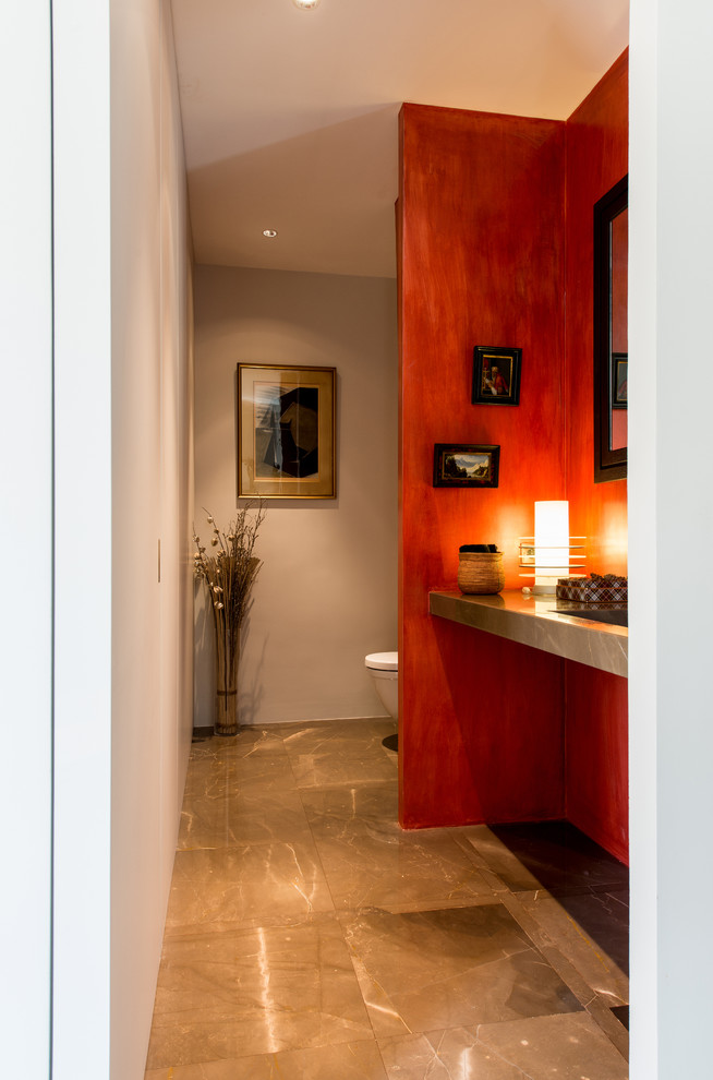 パリにあるモダンスタイルのおしゃれなトイレ・洗面所 (壁掛け式トイレ、大理石の床、横長型シンク) の写真