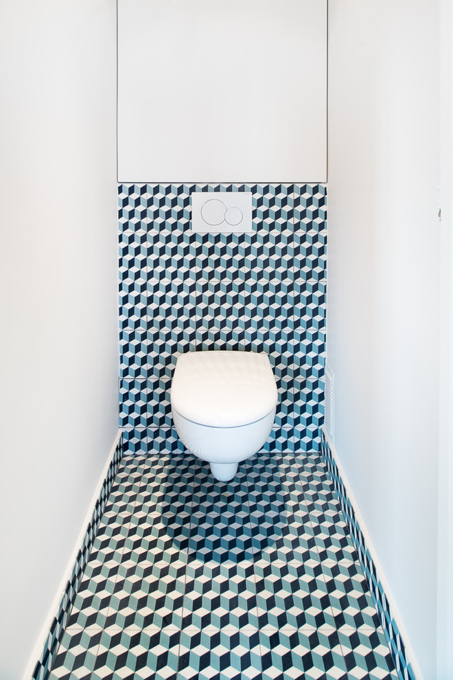 Idéer för att renovera ett litet funkis toalett, med en vägghängd toalettstol, cementkakel, vita väggar, cementgolv, flerfärgad kakel och flerfärgat golv