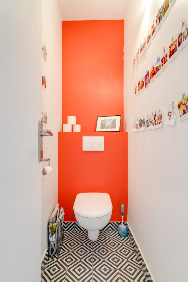 Foto di un bagno di servizio design di medie dimensioni con WC sospeso, pareti rosse, pavimento con piastrelle in ceramica e pavimento nero