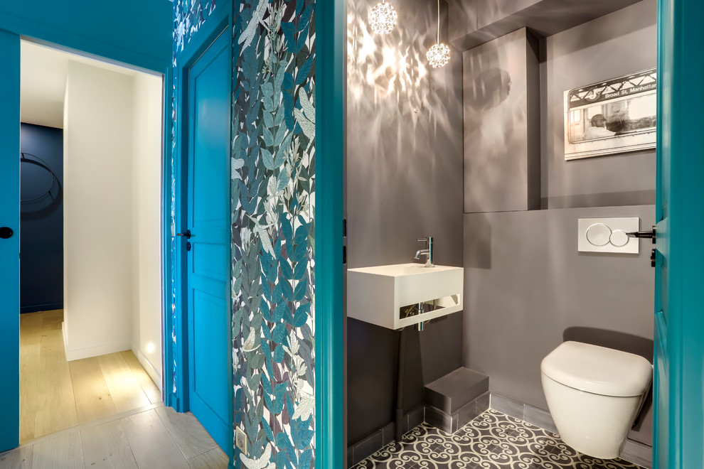 На фото: туалет в современном стиле с инсталляцией, серыми стенами, подвесной раковиной и серым полом с