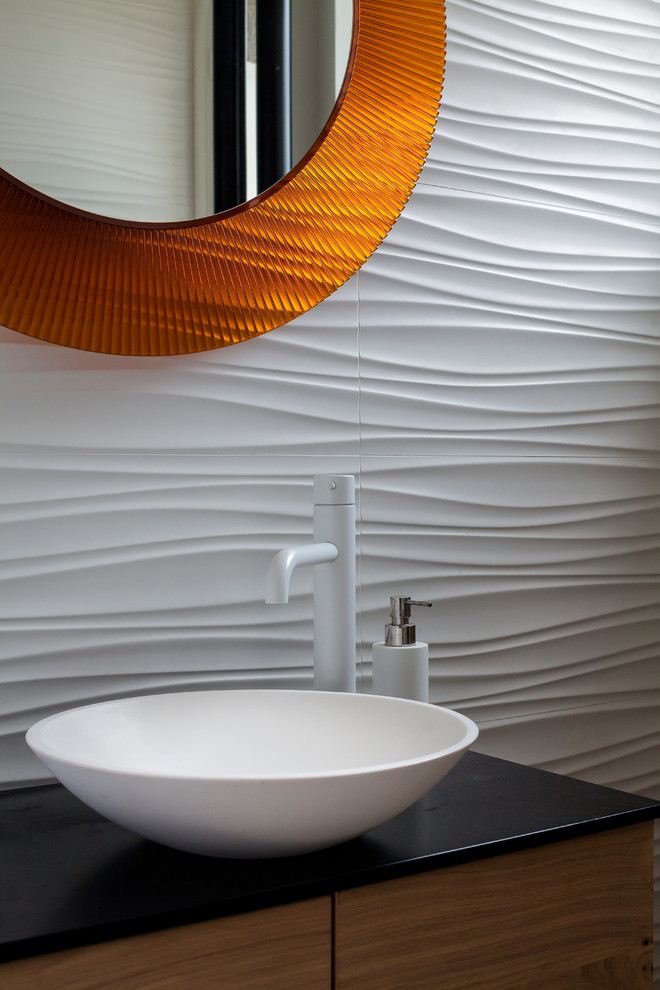 Inspiration för mellanstora moderna toaletter, med en vägghängd toalettstol och vit kakel