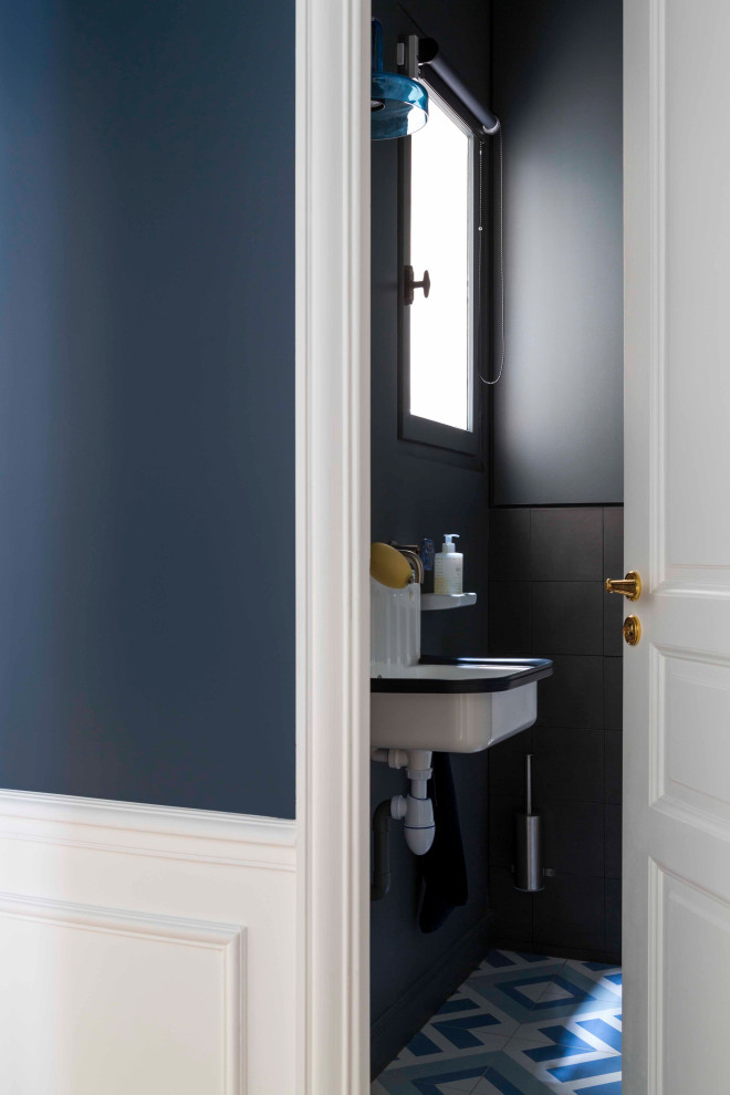 Foto di un piccolo bagno di servizio design con pareti blu, piastrelle nere, piastrelle in ceramica, pavimento in cementine, lavabo sospeso e pavimento blu