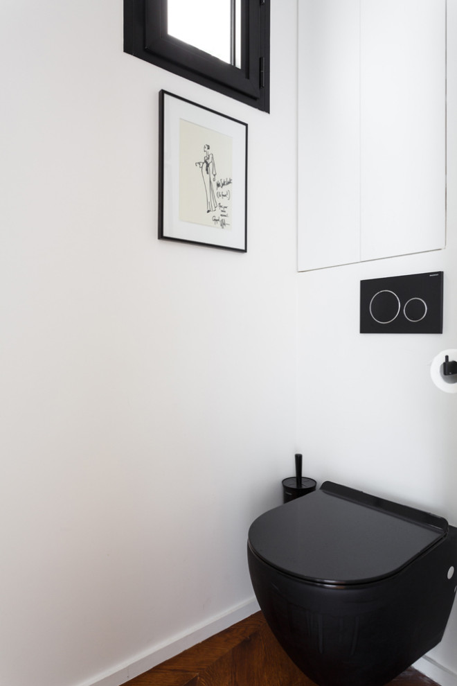 Exemple d'un petit WC suspendu tendance avec un placard à porte affleurante, des portes de placard blanches, un mur blanc, un sol en bois brun, un plan de toilette en surface solide, un sol marron, un plan de toilette noir et meuble-lavabo encastré.