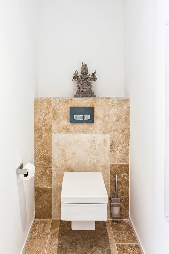 Réalisation d'un petit WC et toilettes asiatique avec un carrelage beige, un mur blanc et un sol marron.