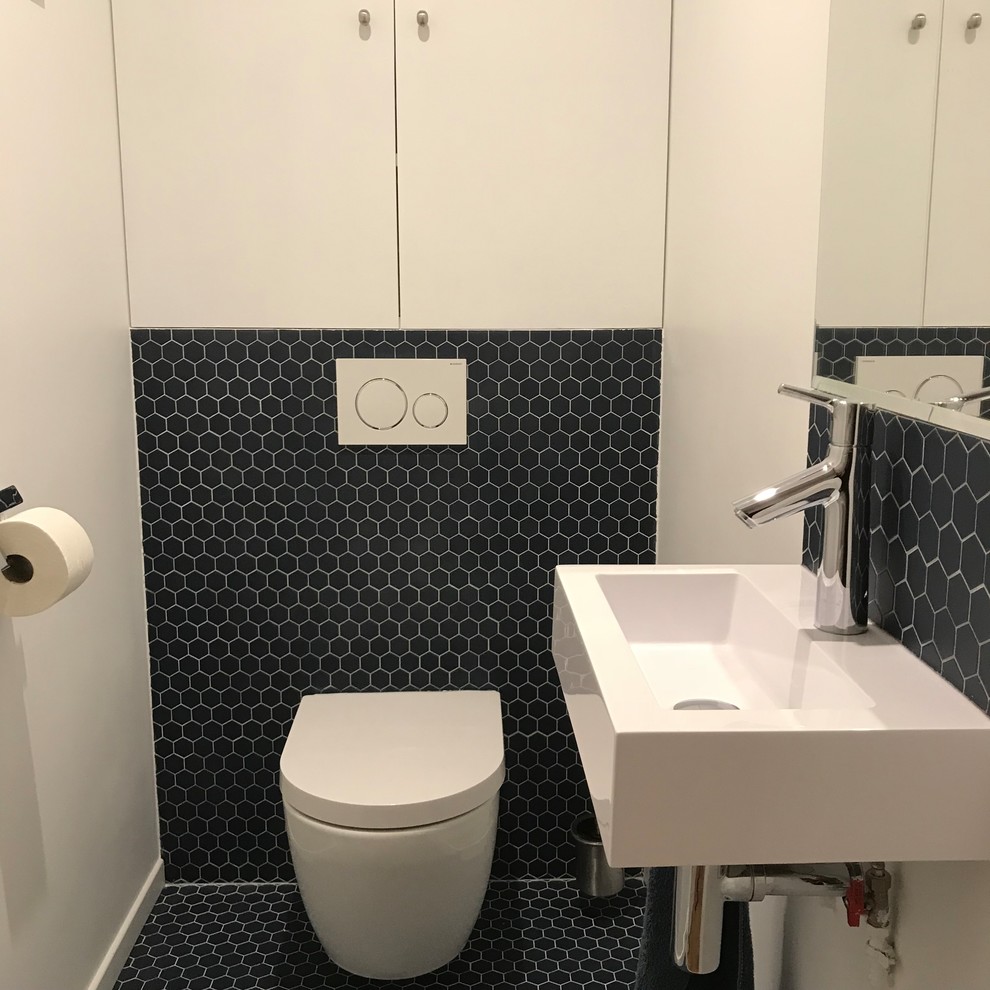 Medium sized contemporary cloakroom in Bordeaux with beaded cabinets, white cabinets, a wall mounted toilet, blue tiles, terracotta tiles, white walls, terracotta flooring, a wall-mounted sink, engineered stone worktops and blue floors.