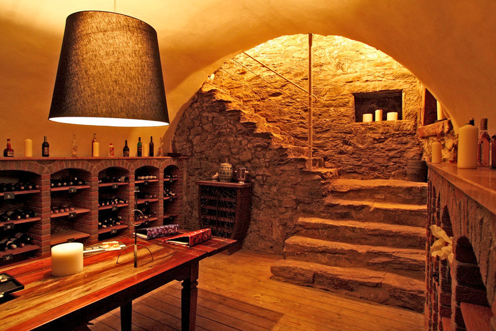 Idées déco pour une cave à vin méditerranéenne de taille moyenne avec un sol en bois brun et des casiers.