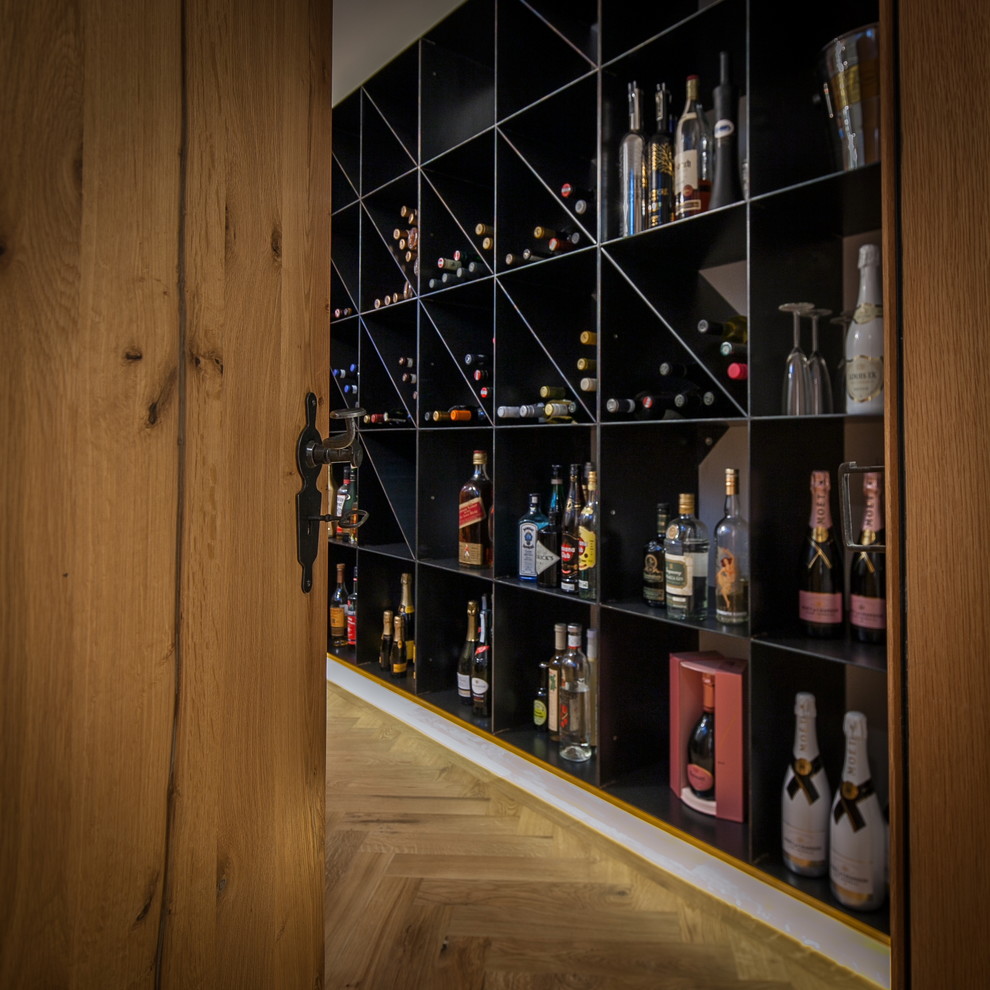 Großer Moderner Weinkeller mit hellem Holzboden, waagerechter Lagerung und braunem Boden in München