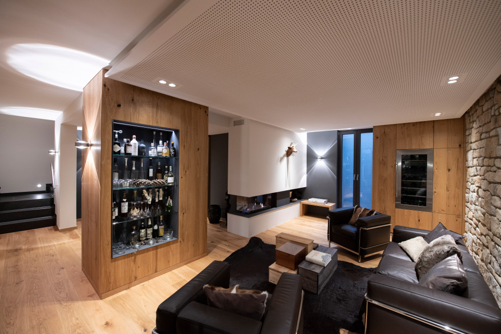 Medium sized industrial wine cellar with medium hardwood flooring, brown floors and display racks.