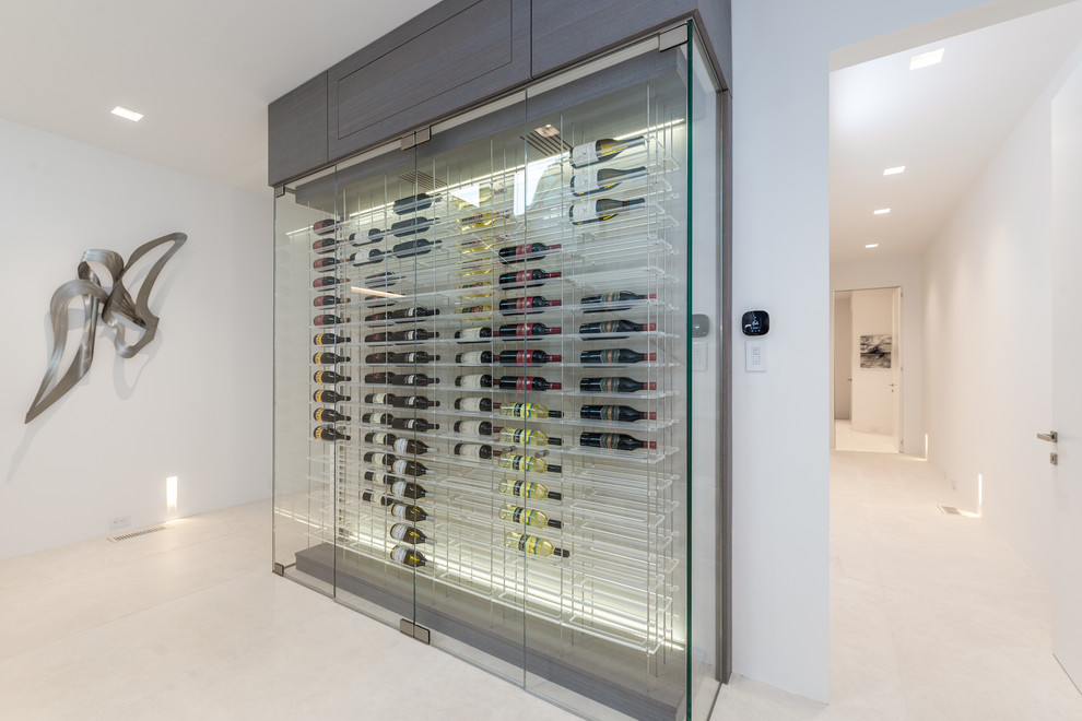 Expansive contemporary wine cellar in New York with light hardwood flooring, display racks and beige floors.