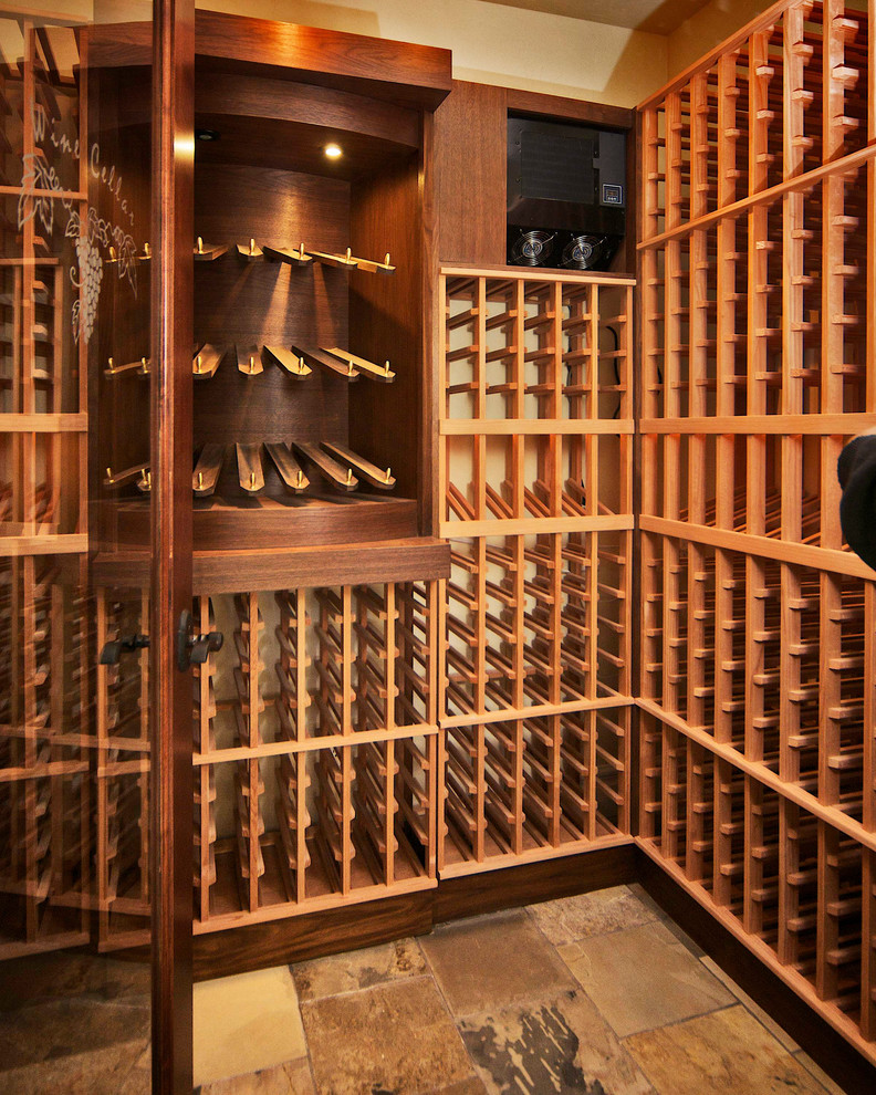 Inspiration for a mid-sized mediterranean slate floor and beige floor wine cellar remodel in Denver with storage racks