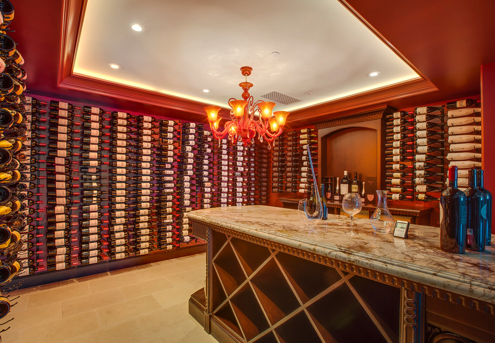 Example of a large tuscan limestone floor wine cellar design in Los Angeles with storage racks
