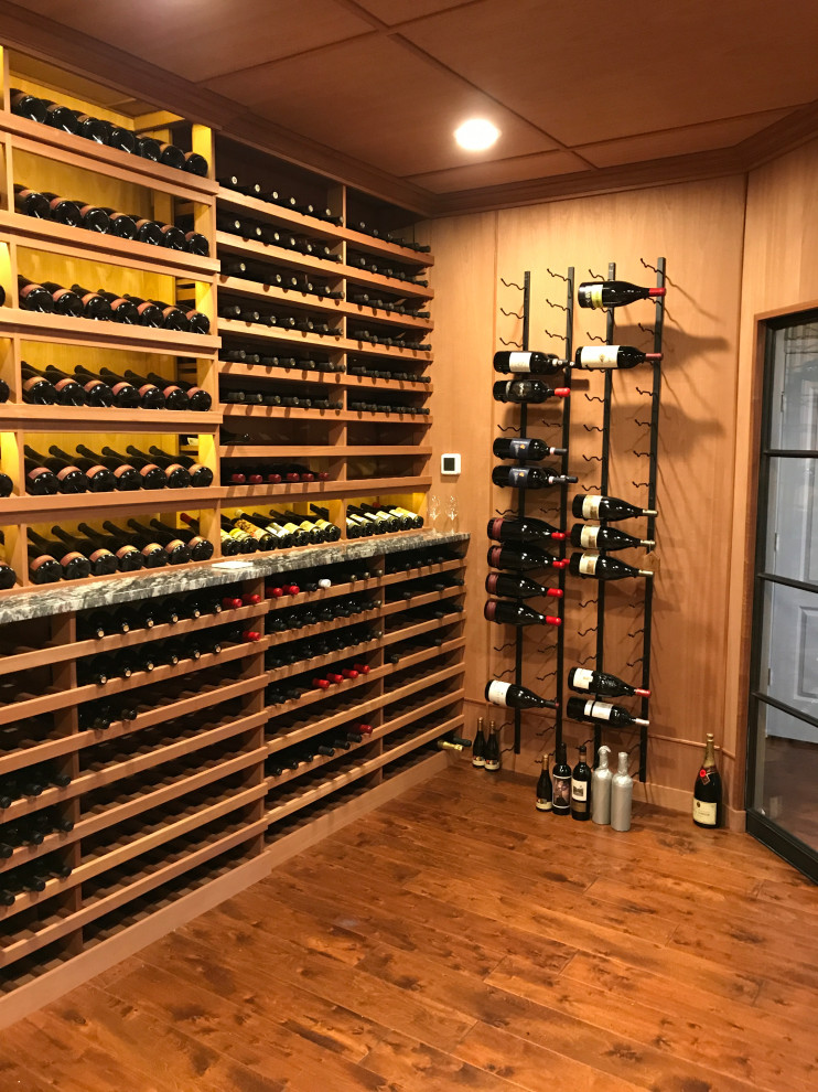 Large traditional wine cellar in New York with medium hardwood flooring, storage racks and brown floors.