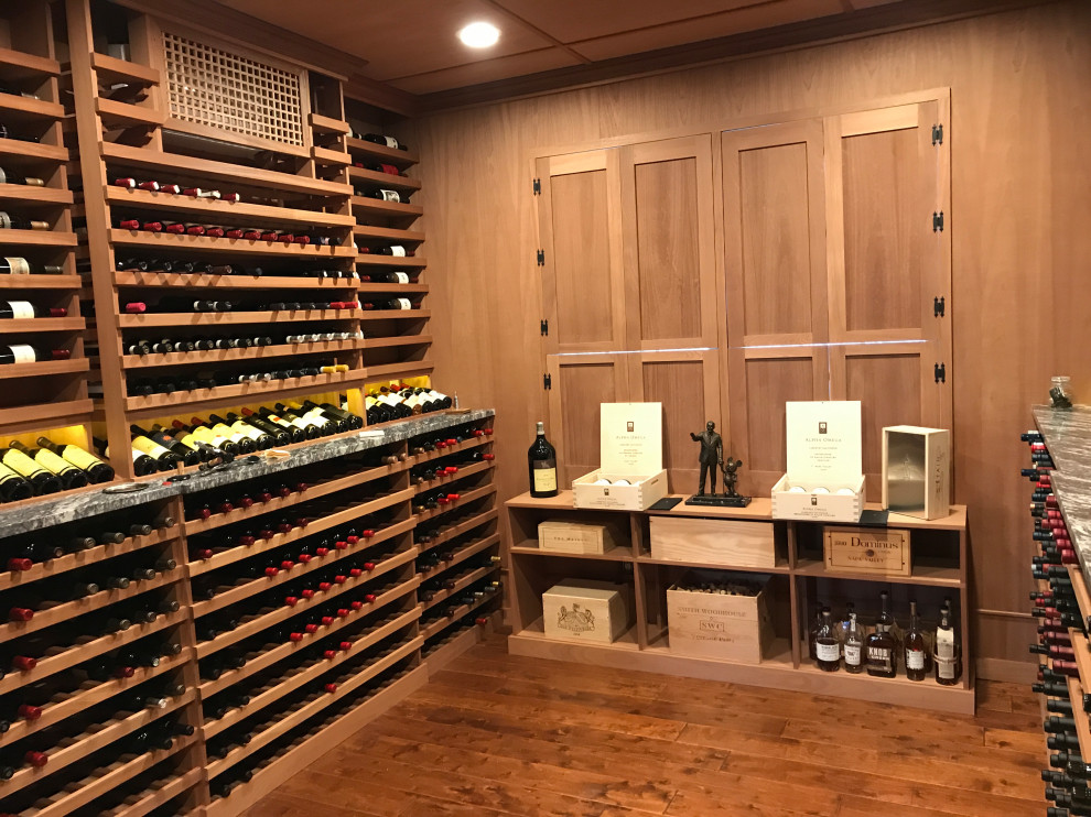 Photo of a large traditional wine cellar in New York with medium hardwood flooring, display racks and brown floors.