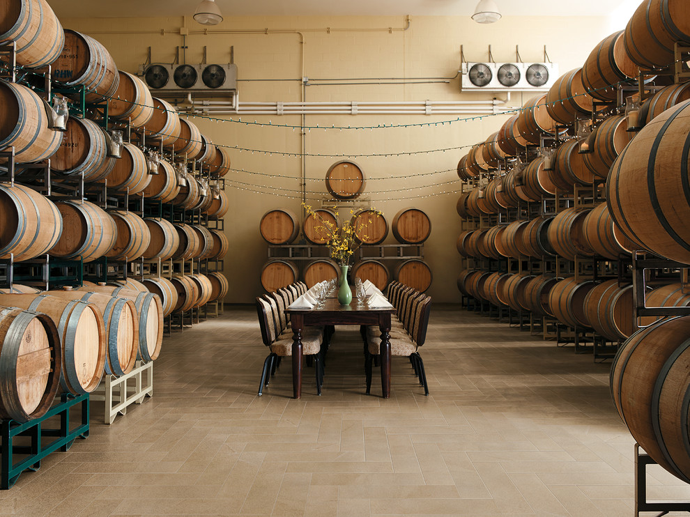 Réalisation d'une grande cave à vin méditerranéenne avec un sol en carrelage de céramique et des casiers.