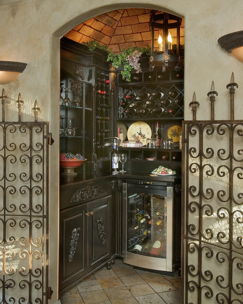 This is an example of a small mediterranean wine cellar in Orlando with travertine flooring, display racks and beige floors.