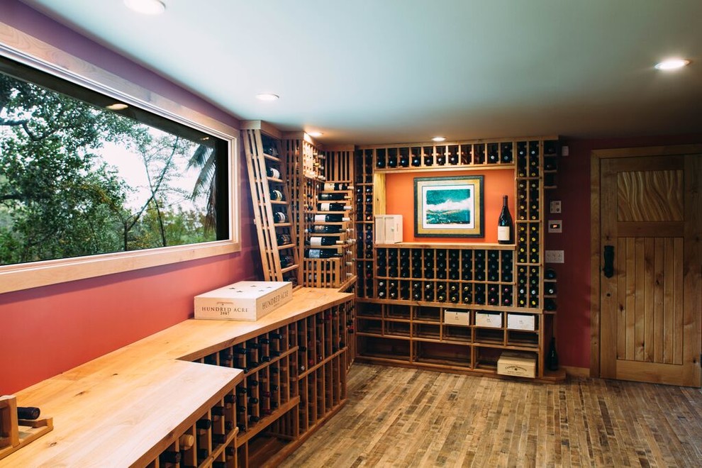 Idéer för att renovera en stor vintage vinkällare, med ljust trägolv och vinhyllor