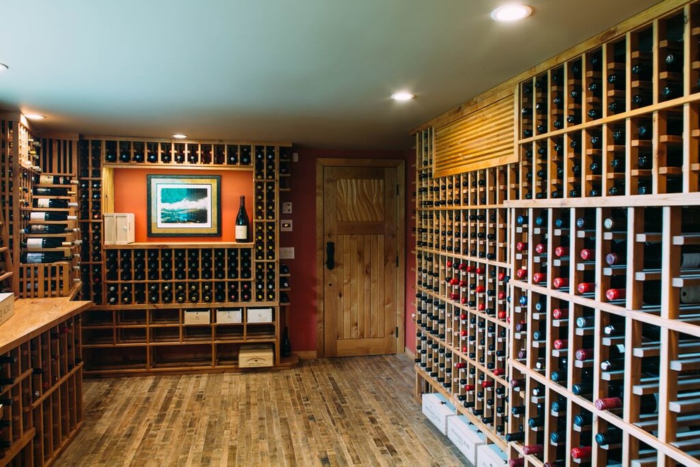 Großer Stilmix Weinkeller mit hellem Holzboden und Kammern in Los Angeles