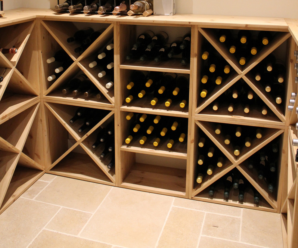 Foto på en mellanstor funkis vinkällare, med vinställ med diagonal vinförvaring, klinkergolv i porslin och beiget golv