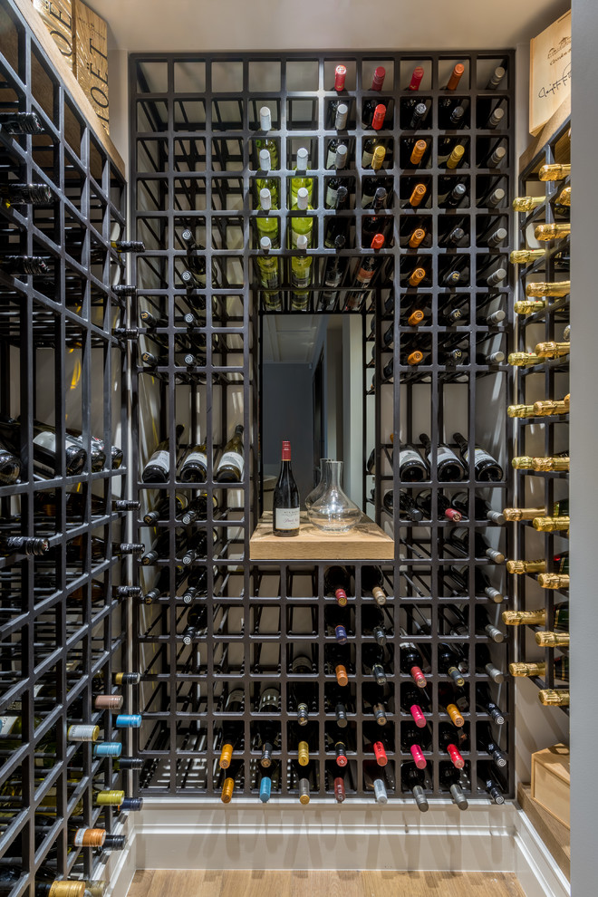 Design ideas for a large traditional wine cellar in Auckland with medium hardwood flooring, display racks and brown floors.