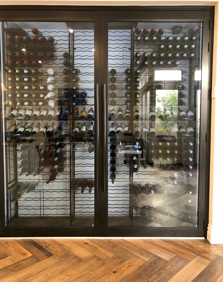 Foto på en mellanstor funkis vinkällare, med vinhyllor och brunt golv