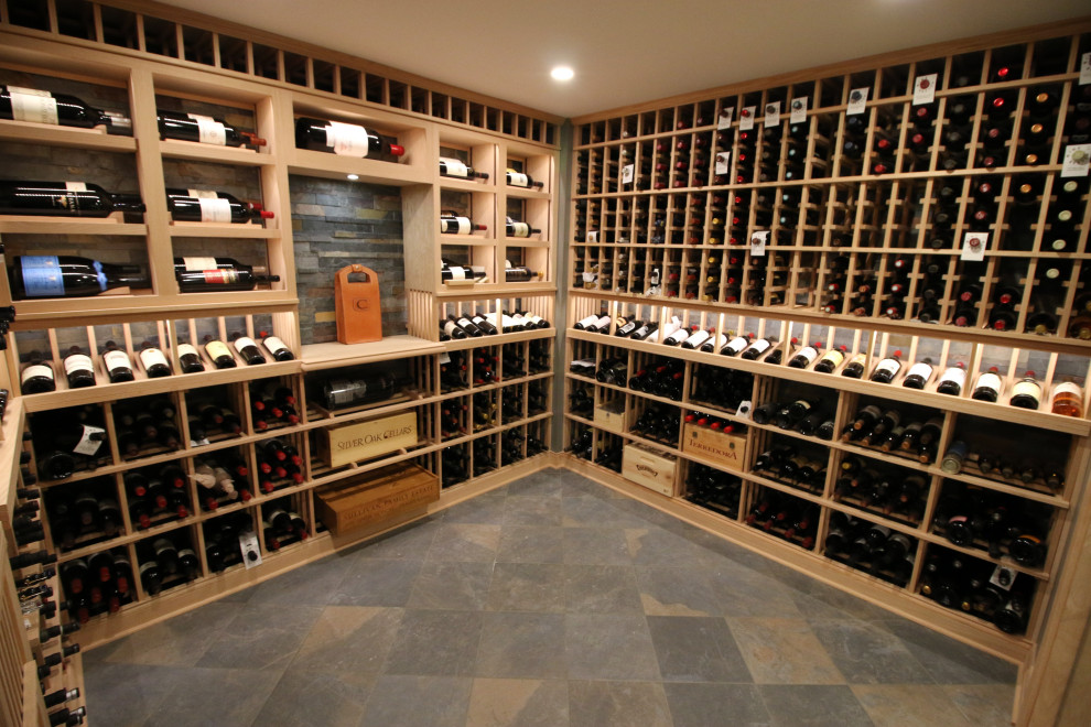 This is an example of a large traditional wine cellar in Cincinnati with slate flooring and display racks.