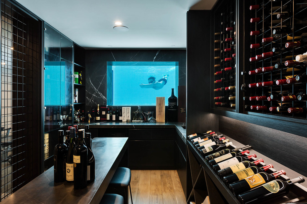 Expansive contemporary wine cellar in Melbourne with light hardwood flooring, display racks and brown floors.