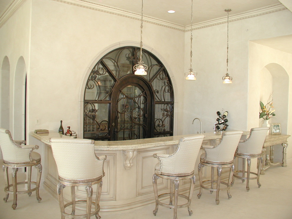 Example of a large tuscan beige floor home bar design in Las Vegas
