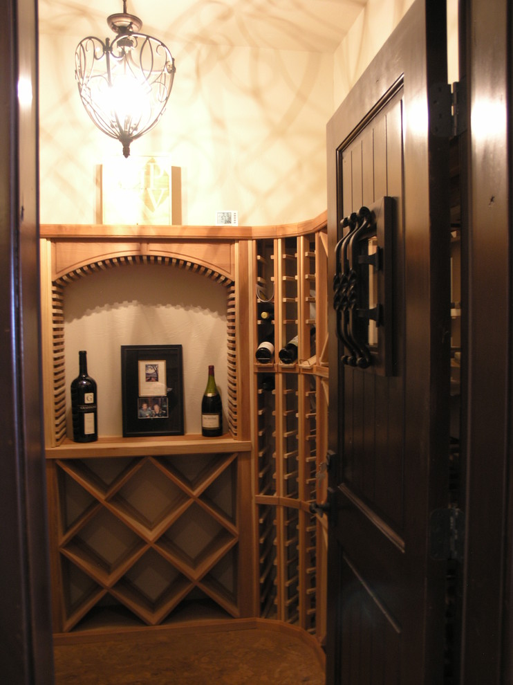 Wine cellar - mid-sized traditional carpeted and brown floor wine cellar idea in Denver with diamond bins