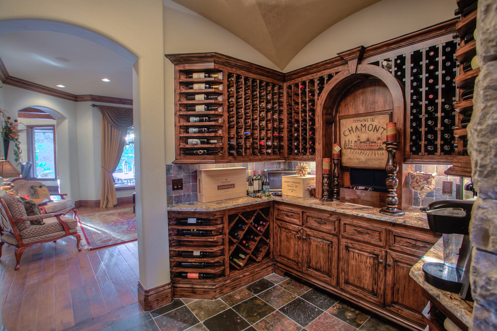 Medium sized rustic wine cellar in Oklahoma City with slate flooring, storage racks and multi-coloured floors.