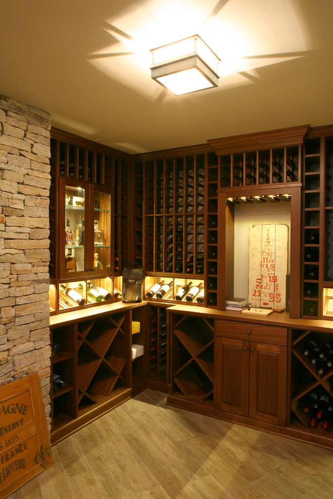 Example of a mid-sized classic medium tone wood floor wine cellar design in New York with display racks