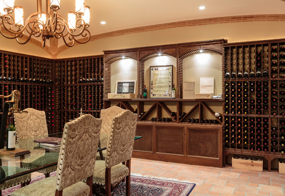 Bild på en mycket stor medelhavsstil vinkällare, med klinkergolv i terrakotta och vinhyllor