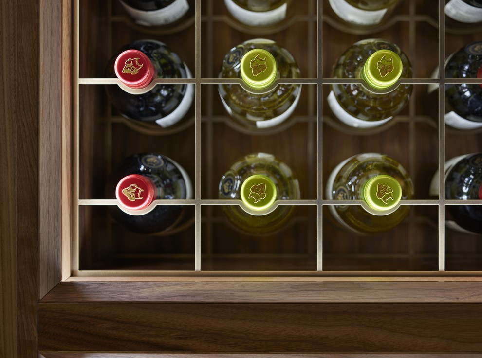 Photo of a small classic wine cellar in Kent with light hardwood flooring, display racks and brown floors.