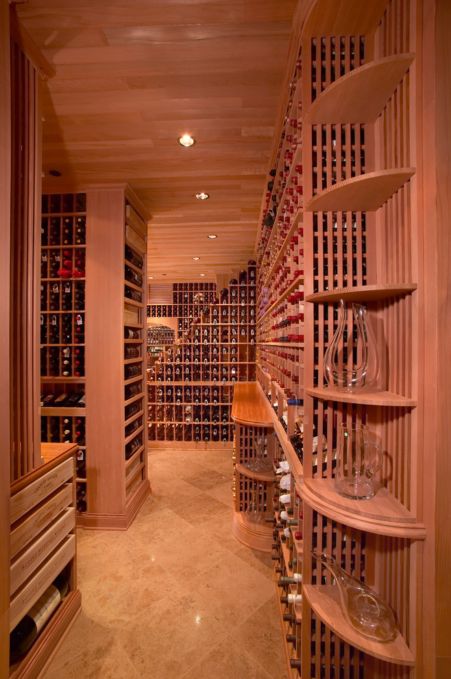 Cette image montre une grande cave à vin style shabby chic avec tomettes au sol et un présentoir.