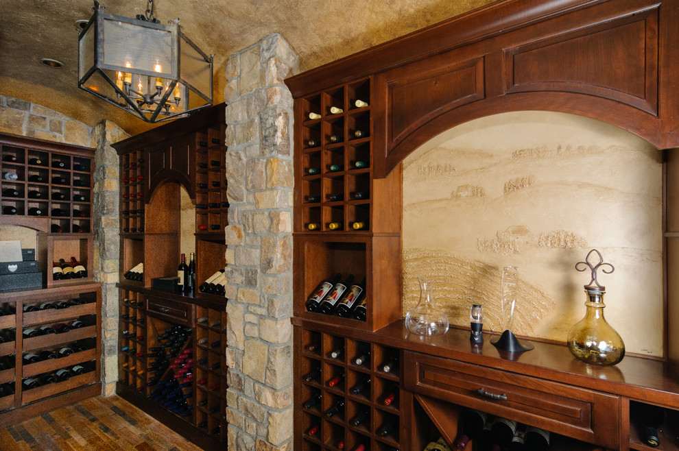 Aménagement d'une cave à vin classique de taille moyenne avec un sol en bois brun et des casiers.