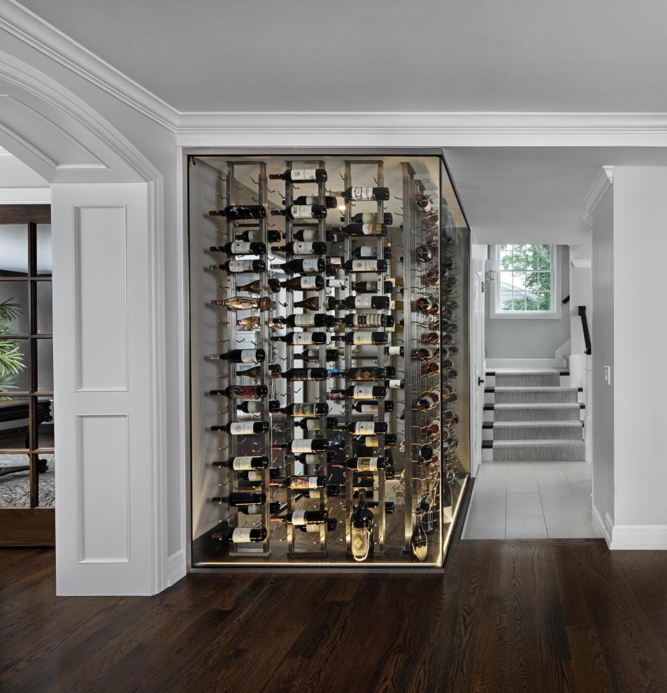 Foto de bodega clásica renovada de tamaño medio con suelo de madera oscura, botelleros y suelo marrón