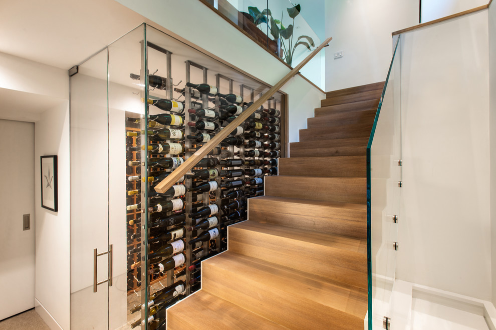 Mittelgroßer Moderner Weinkeller mit hellem Holzboden, diagonaler Lagerung und braunem Boden in New York
