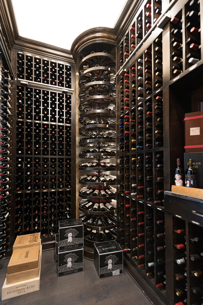 Photo of a mediterranean wine cellar in Houston with storage racks and grey floors.