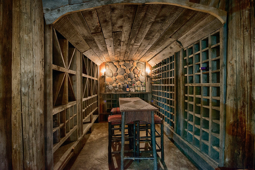 Idées déco pour une cave à vin montagne de taille moyenne avec sol en béton ciré et des casiers.