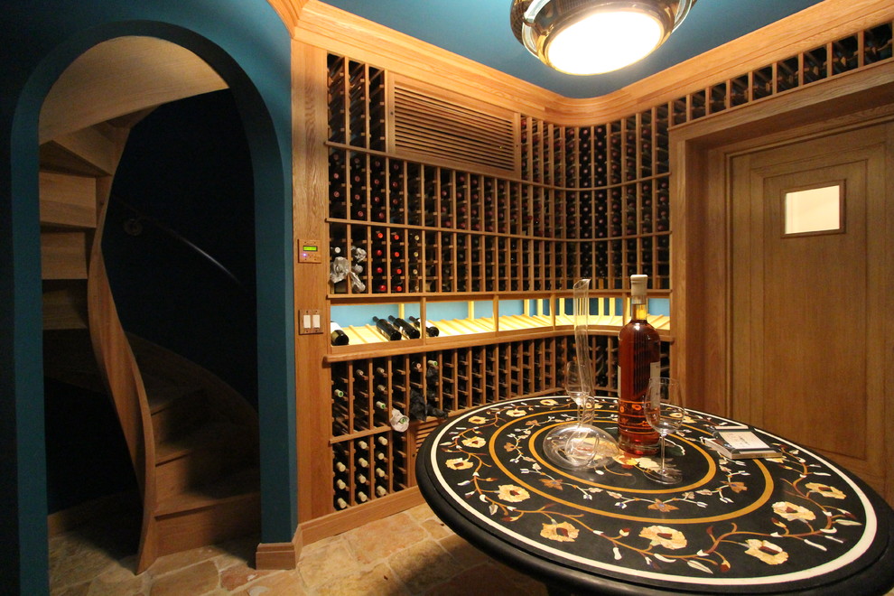 Cette photo montre une grande cave à vin chic avec un sol en travertin, des casiers et un sol beige.