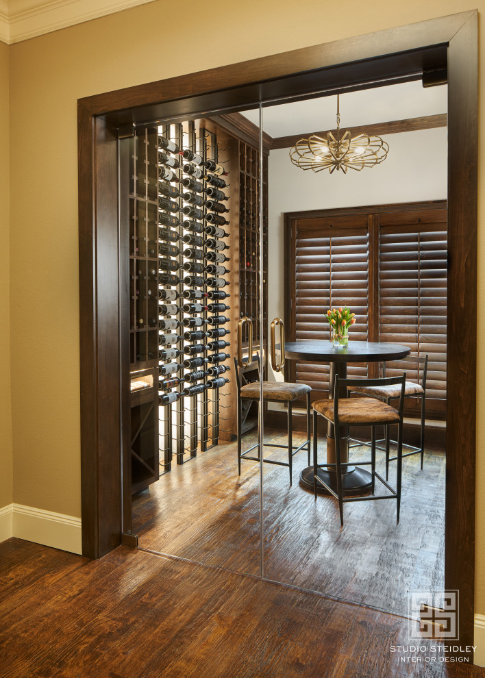 Inspiration for a mid-sized transitional medium tone wood floor and brown floor wine cellar remodel in Dallas with display racks
