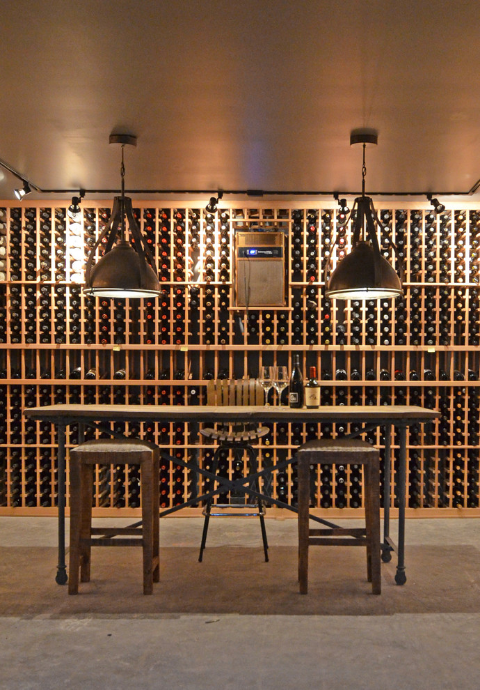 Large urban concrete floor wine cellar photo in Seattle with storage racks