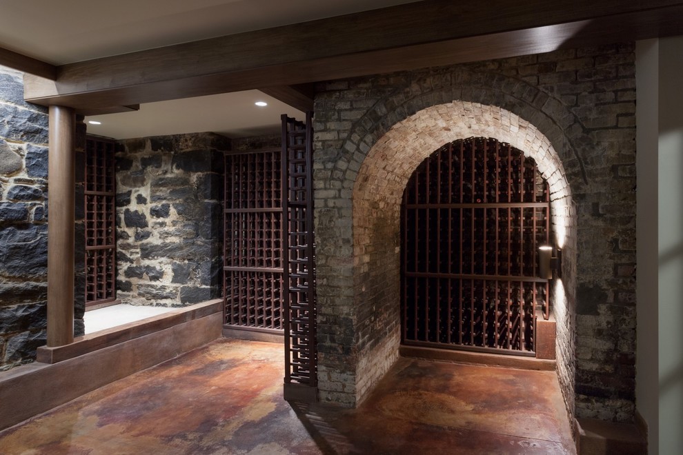 Wine cellar - large rustic concrete floor wine cellar idea in New York with storage racks