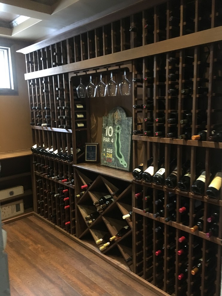 This is an example of a small wine cellar in Salt Lake City with storage racks and brown floors.