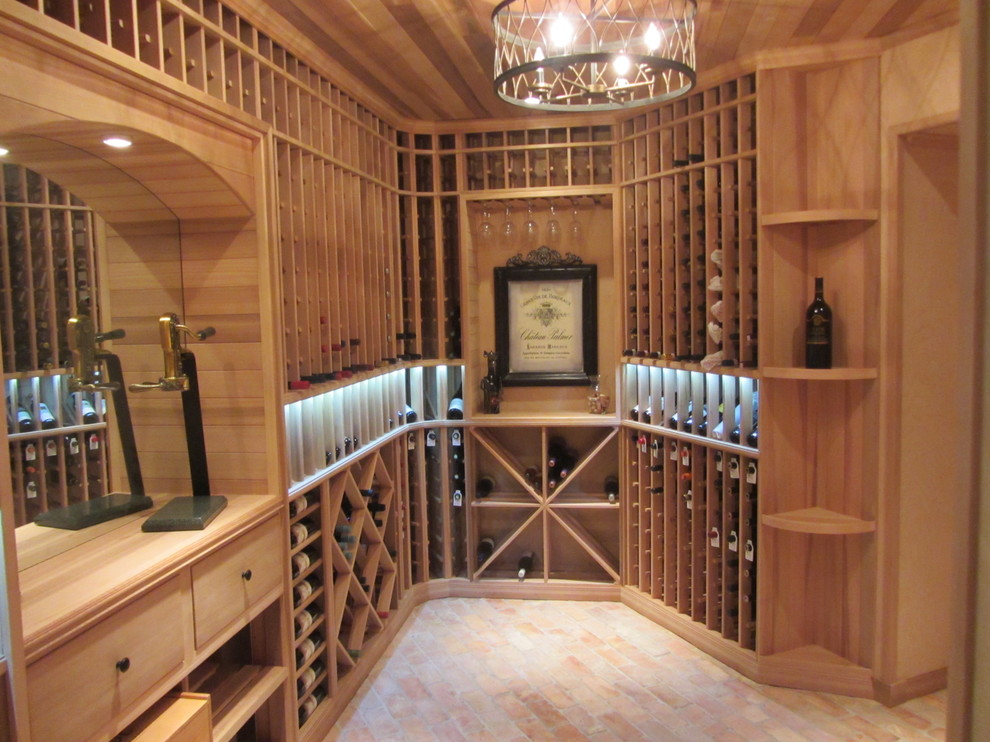 Cette image montre une cave à vin traditionnelle de taille moyenne avec un sol en brique, des casiers losange et un sol rouge.