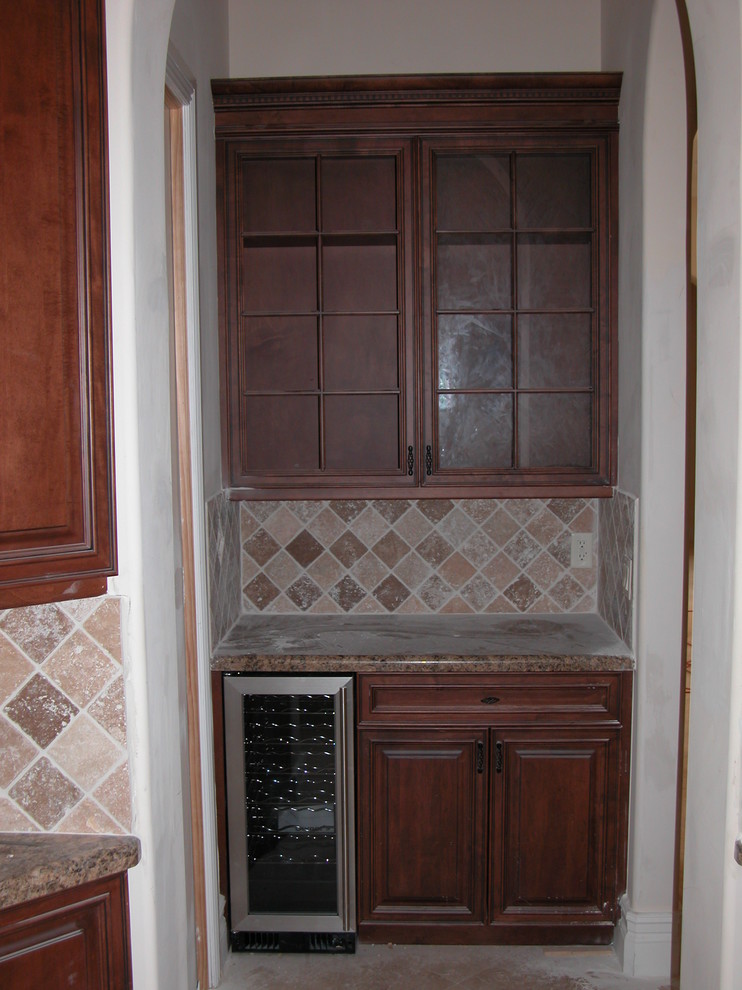 This is an example of a small traditional wine cellar in Miami with travertine flooring and display racks.