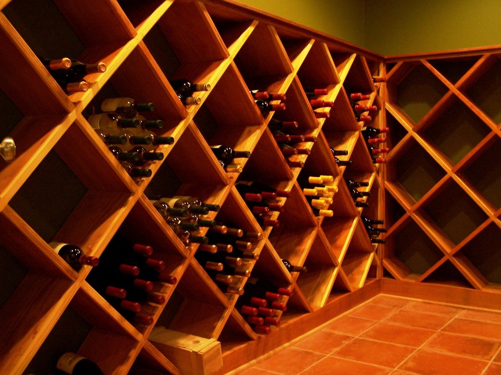 Exemple d'une grande cave à vin chic avec tomettes au sol et des casiers losange.