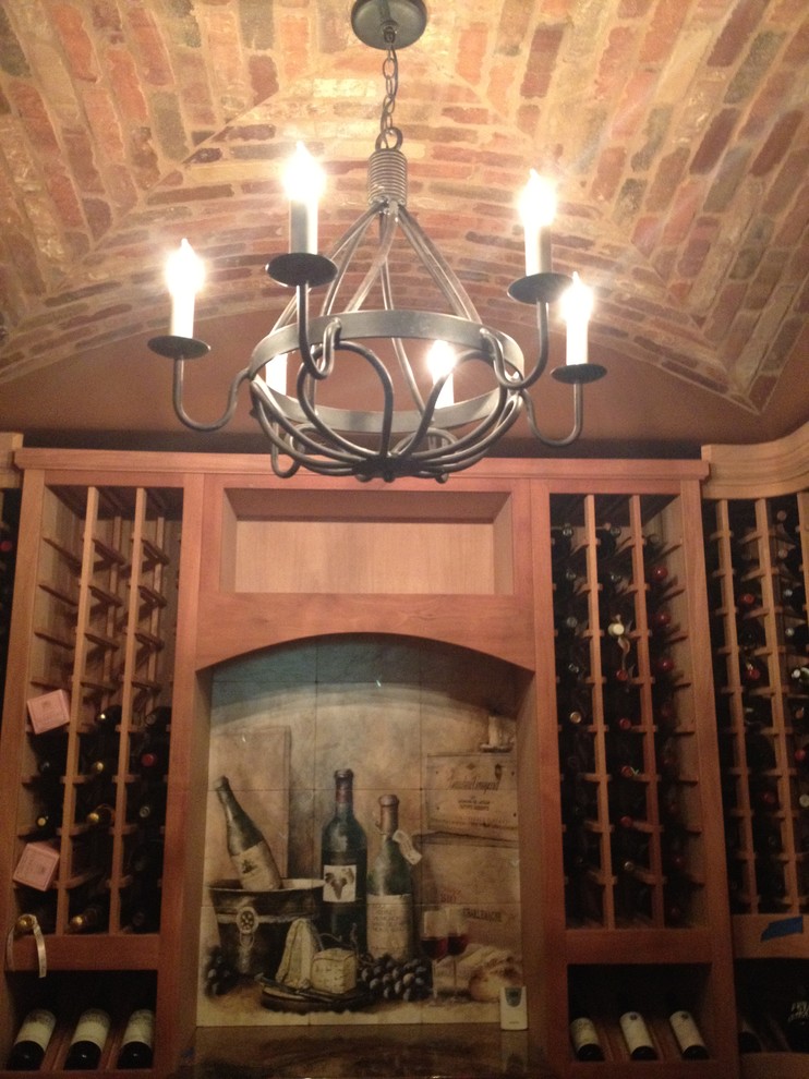 Foto på en stor medelhavsstil vinkällare, med travertin golv och vinhyllor