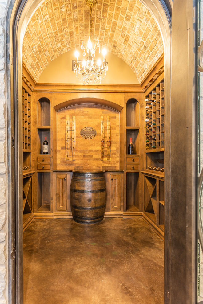 This is an example of a medium sized traditional wine cellar in Other with concrete flooring, storage racks and brown floors.