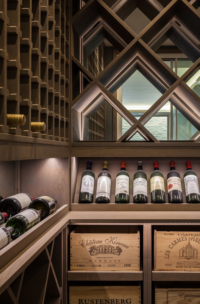 Example of a mid-sized trendy wine cellar design in London with display racks