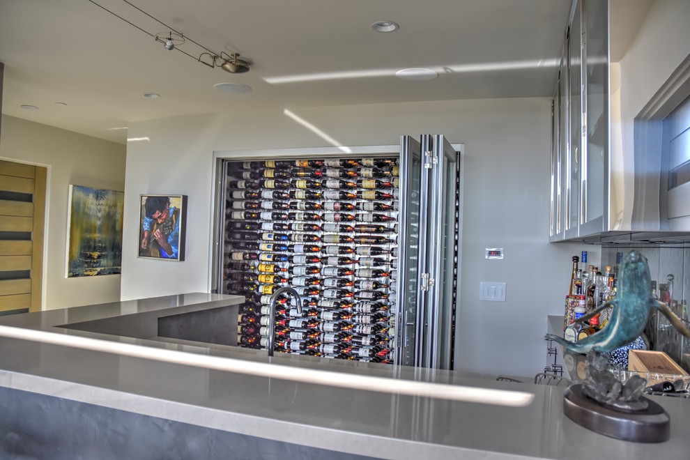 Mid-sized beach style light wood floor wine cellar photo in San Diego with display racks